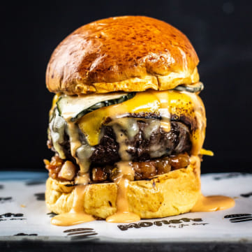 Joe Burger showcasing one of his burgers created at the Moflete by Joe Burger burger joint in Madrid, Valencia and Cuenca
